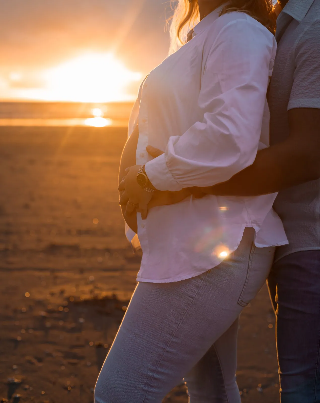 Zwangere vrouw bij zonsondergang fotoshoot op het strand